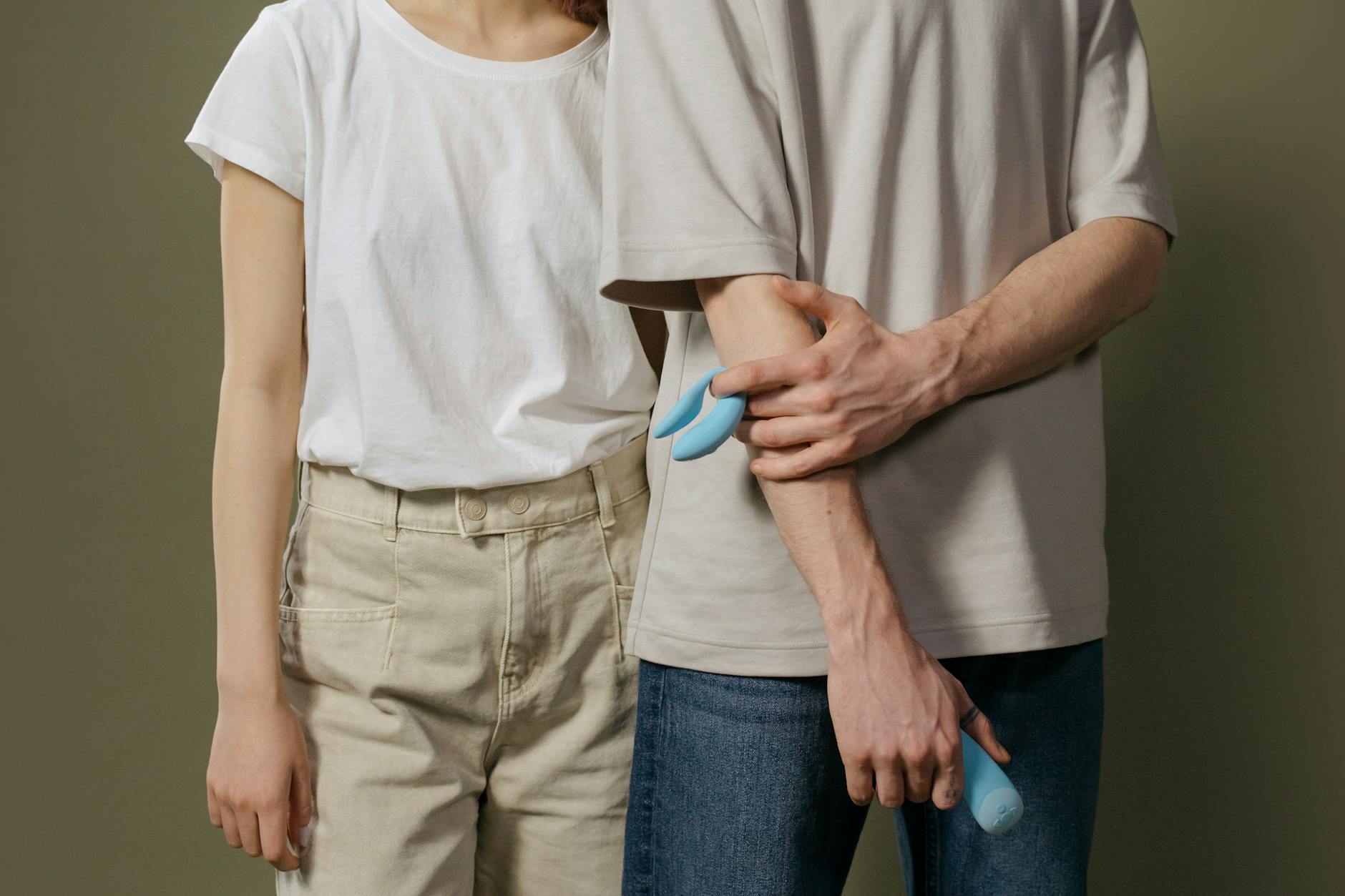 Woman thoughtfully holding a vibrator, representing the gentle return to pleasure after loss